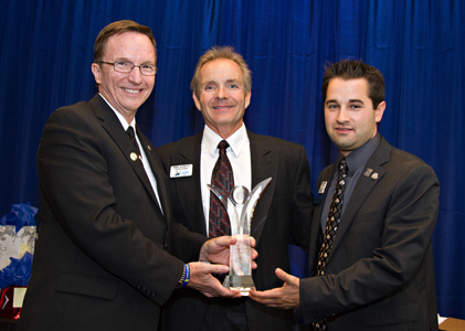 2015 AAR President Jim Sexton presents the Community Outreach Award in the Association category to Phil Annett and Aaron Pfeifer representing the Lake Havasu Association of REALTORS®